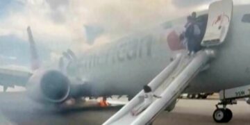 Passengers flee on emergency slide after American Airlines Boeing in Denver suffers landing gear fire