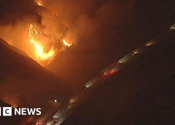 California wildfires burn near passing vehicles