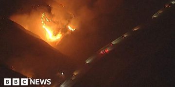 California wildfires burn near passing vehicles