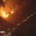 California wildfires burn near passing vehicles
