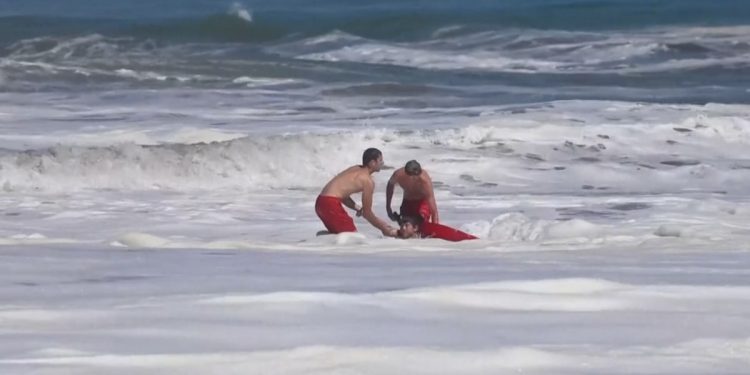 Dramatic video shows a 10-year-old boy rescued from pounding waves