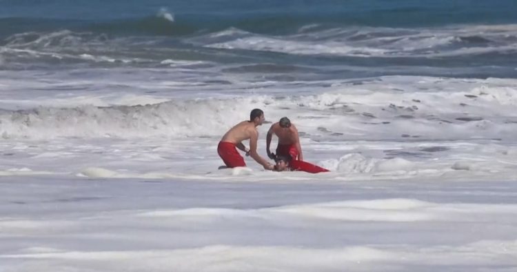Dramatic video shows a 10-year-old boy rescued from pounding waves